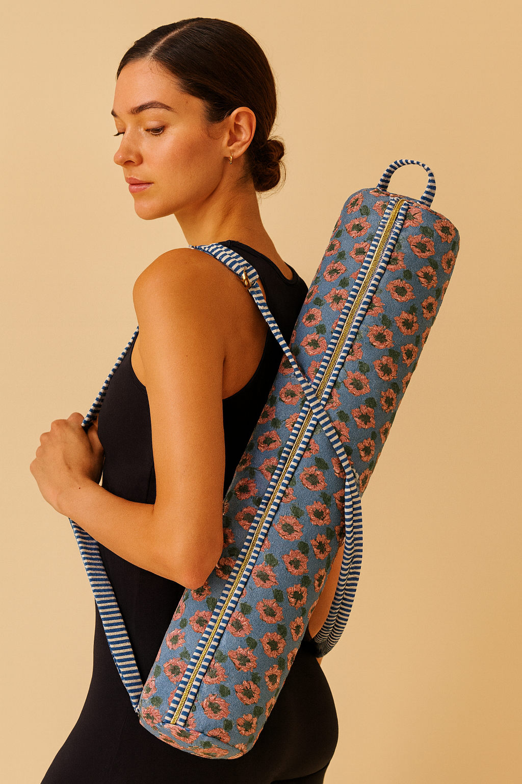 Woman carrying a floral-patterned yoga mat bag on a beige background