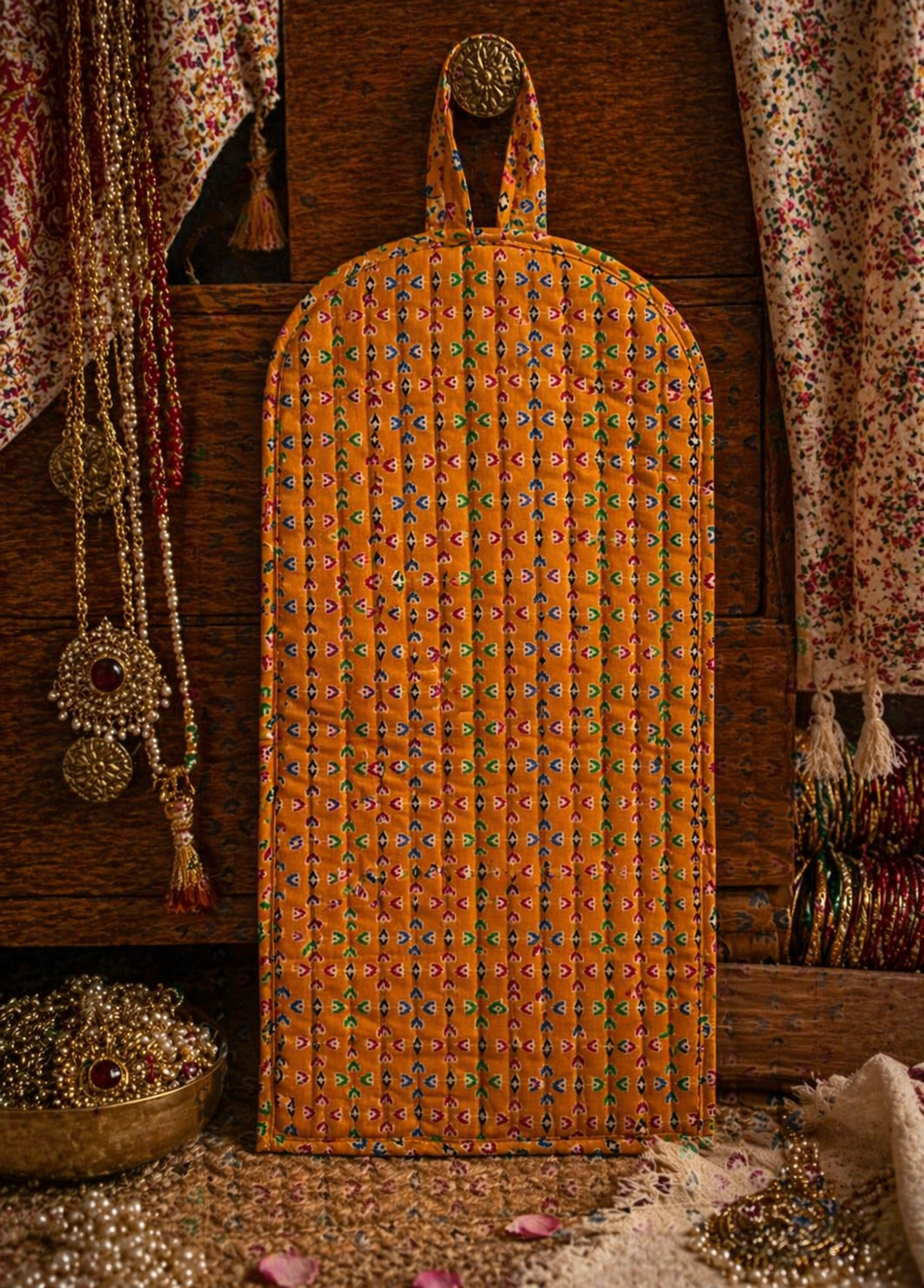 Decorative orange exterior of jewellery stacker/organiser cover with intricate patterns on a wooden background.