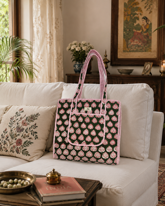 Decorative bag with a pink and dark green pattern on a white sofa in a living room setting.