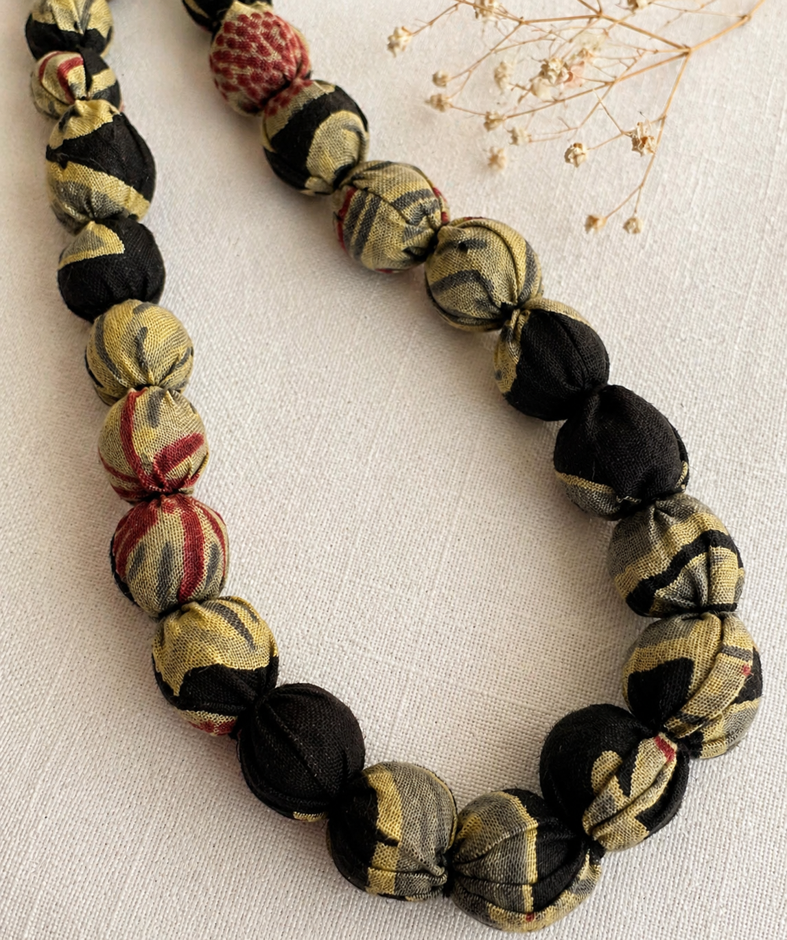 Necklace made of patterned fabric beads on a light background