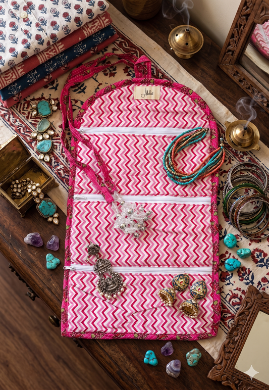 Pink and white zigzag-patterned interior of a organiser bag with jewellery on a wooden surface